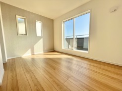 2階主寝室6.5帖は、バルコニーに面した明るいお部屋◎
「やさしい光がふんわり包み込む、心ほどける洋室。家具を置いてもゆったり使える広さで、子ども部屋にも寝室にもぴったり。窓からの景色が毎日に小さな癒しをくれる、家族みんなが“自分の好き”を楽しめる空間です。」