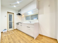 床下収納や勝手口もあるシステムキッチンは新品に交換済み。清潔感のある白色で統一されたキッチン。