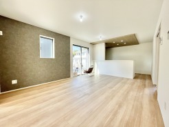 4号棟 大きな窓からたっぷり光が入る、明るく広々としたリビング。
木目調のフロアと白い壁が優しい雰囲気を演出し、家族団らんにぴったりの空間です。
キッチンとのつながりもよく、料理中も会話が楽しめるオープンな間取りです。